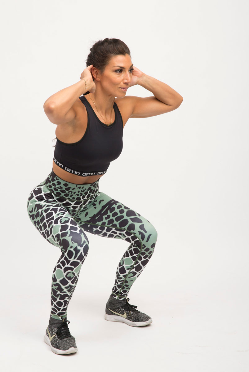 Tränaren gör knäböj.